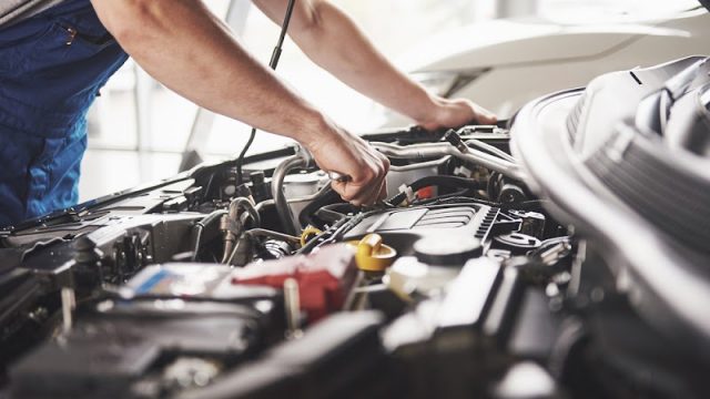 Auto mechanic working in garage. Repair service.